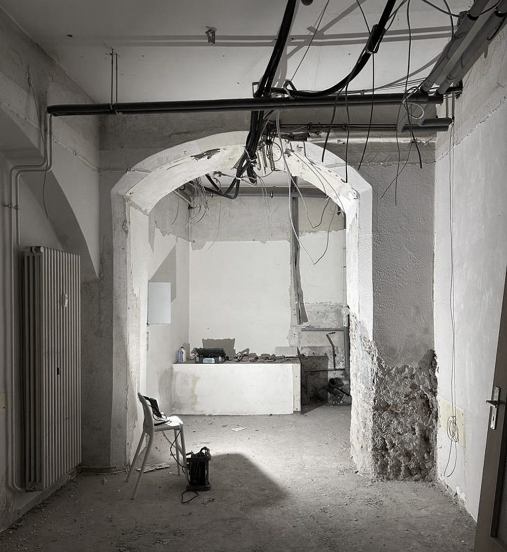 The shop before the works: vaulted arches and exposed pipes